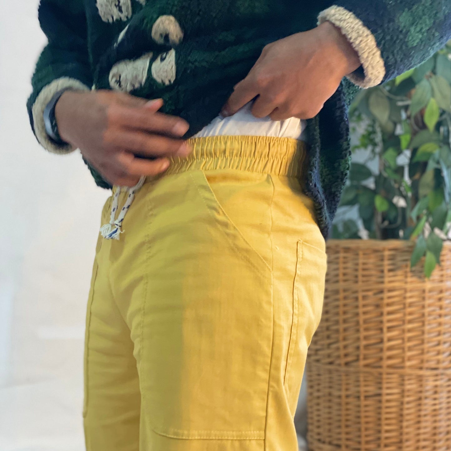 Model wearing mustard coloured pants with a wool plaid jersey against a white backdrop.
