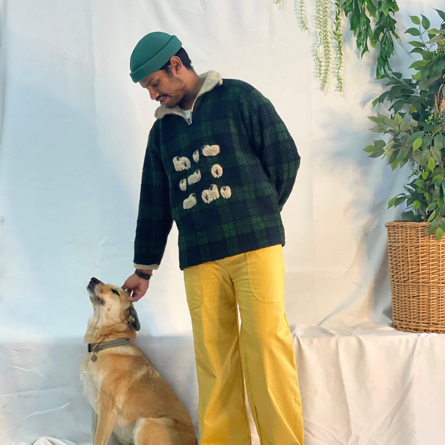 Model wearing mustard coloured pants with a wool plaid jersey against a white backdrop.