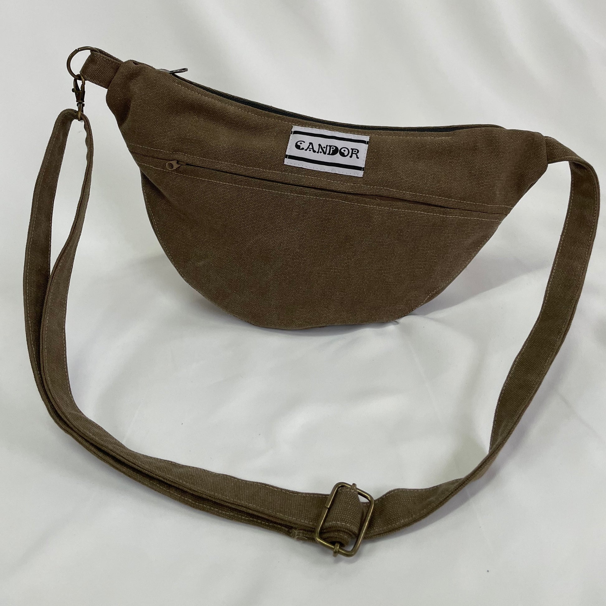 Brown sling bag with topstitching, brass hardware and YKK zips,